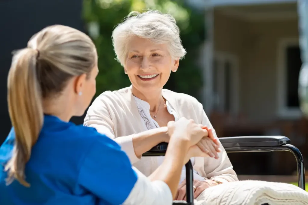 Un soignant ou un proche tenant doucement la main d'une personne âgée, exprimant la bienveillance et le réconfort